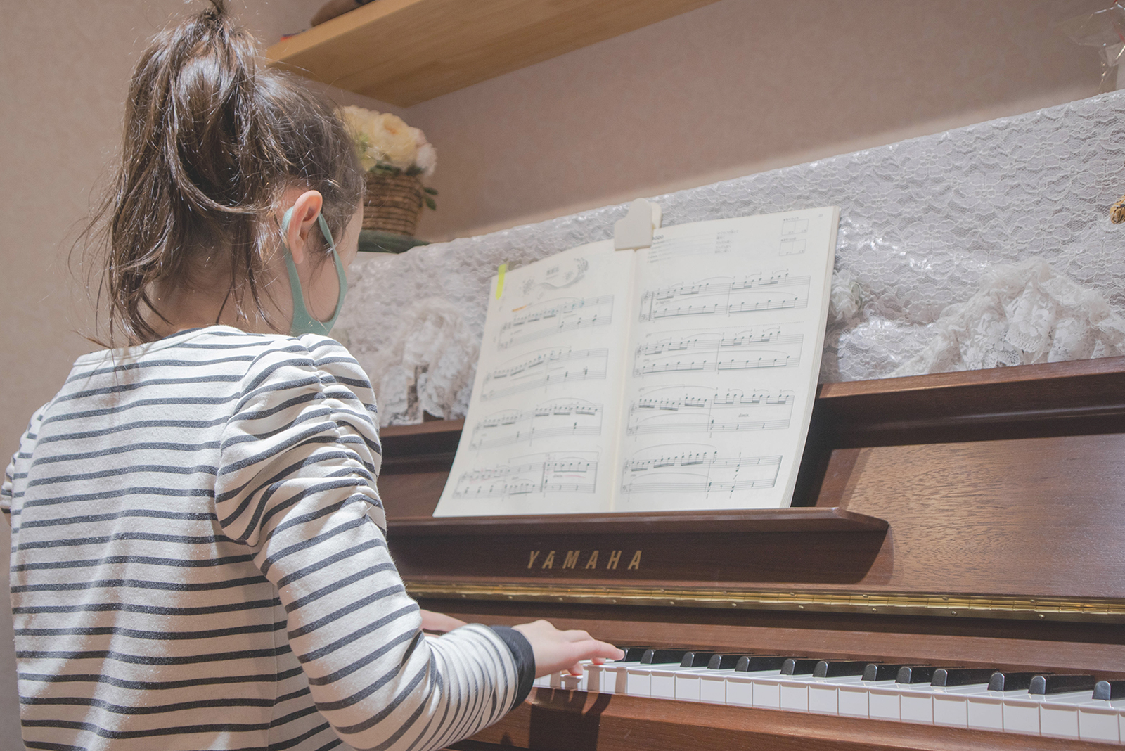 アップライトピアノを弾く女の子
